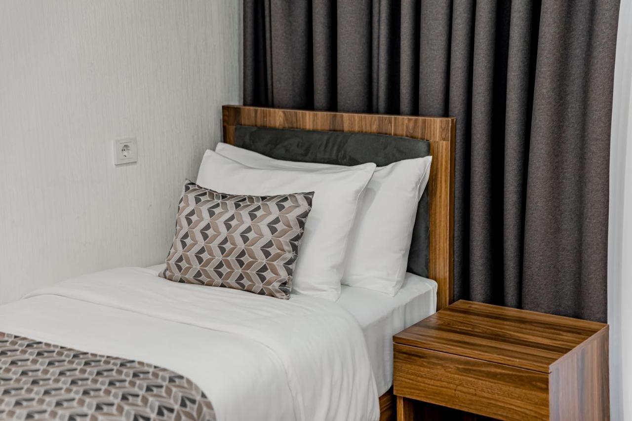 Kutaisi Inn Exterior photo A bed with a throw pillow